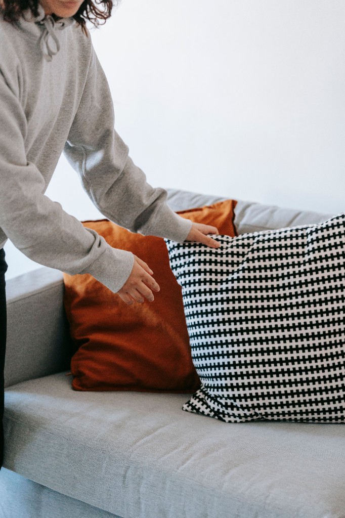 Arranging cushions on a living room sofa
